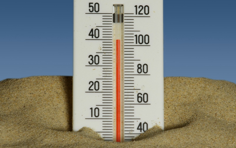 A thermometer standing in sand, showing 40 degrees C.