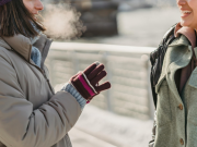 Two people having a discussion on a cold winter's day, with their breath heavily visible in the air.